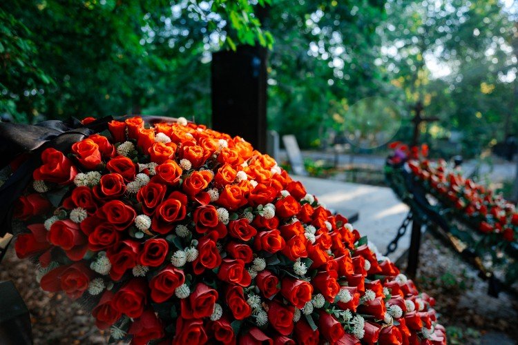 Уссыпанная цветами могила на кладбище