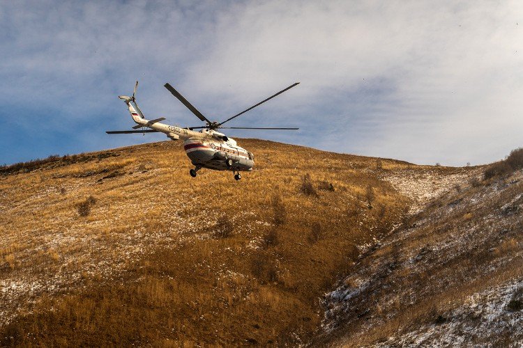Вертолет летит в горах