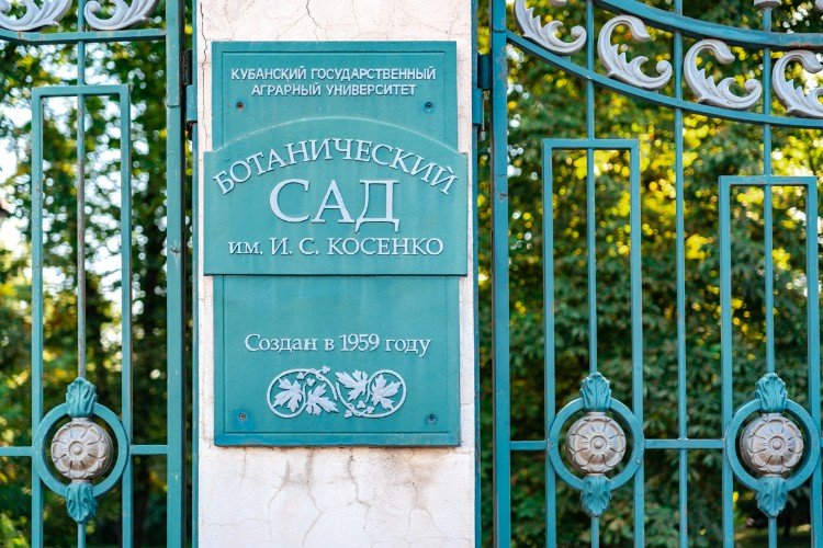 табличка ботанического сада на заборе