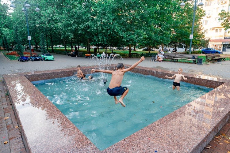 ребенок прыгает в фонтан