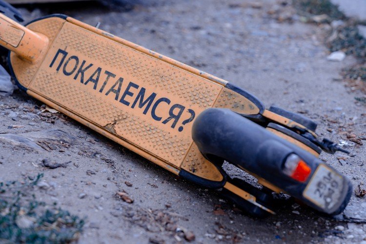самокат лежит на земле