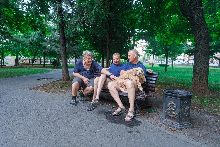 Мужчины с собакой отдыхают в сквере в Краснодаре