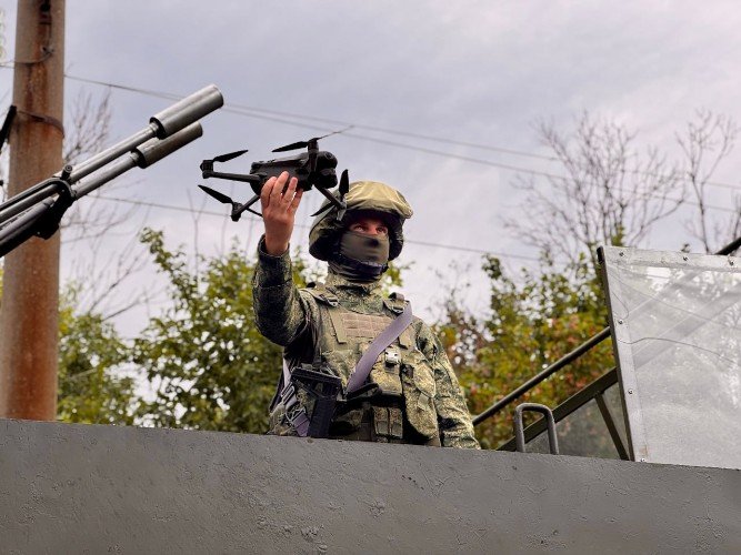 Российский военный держит дрон в руке