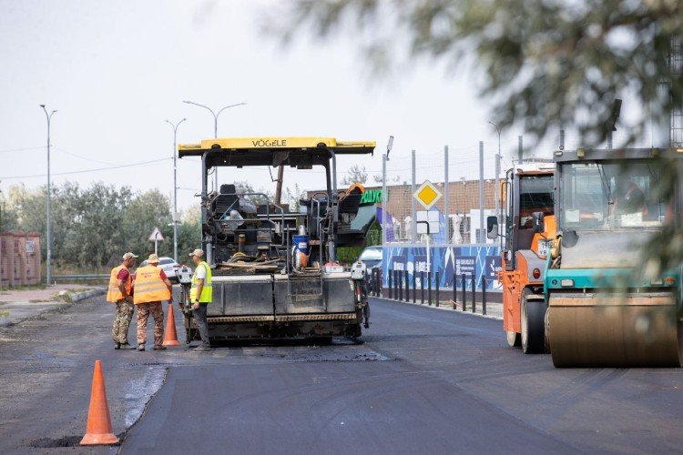рабочие укладывают асфальт на дороге
