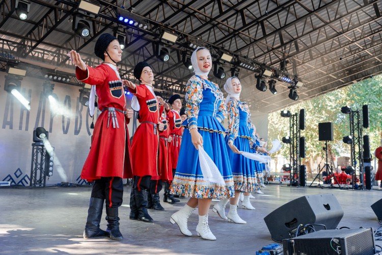 Юноши и девушки танцуют в национальных костюмах на сцене в Усть-Лабинске