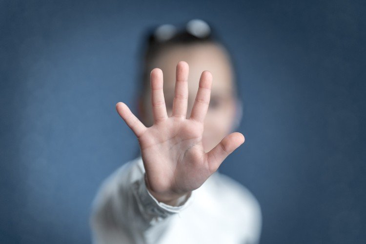 Девочка закрывает лицо рукой