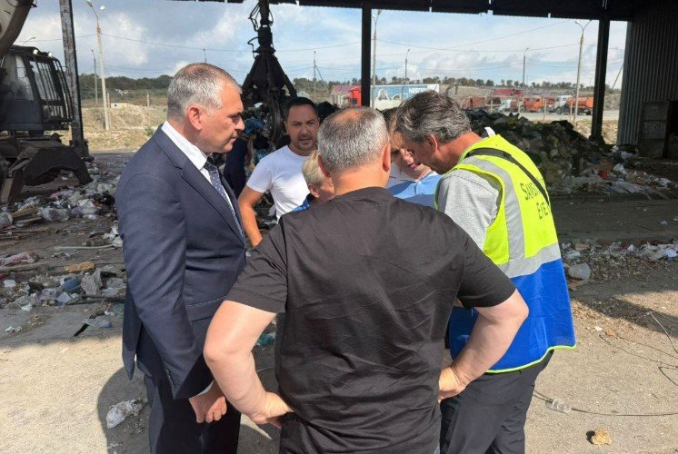 группа мужчин стоит на свалке