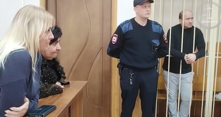 мужчина стоит за решетков в зале суда