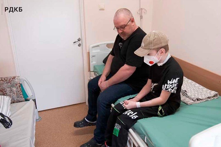 ВАля Королев сидит с отцом на кровати