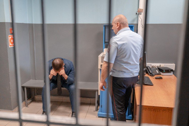 мужчина сидит в полиции