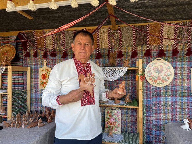 мужчина держит игрушки из глины