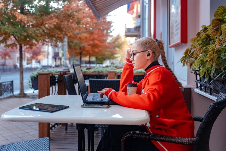 девушка сидит за столом с ноутбуком