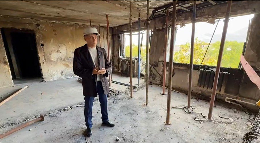 мужчина стоит в разбитой квартире