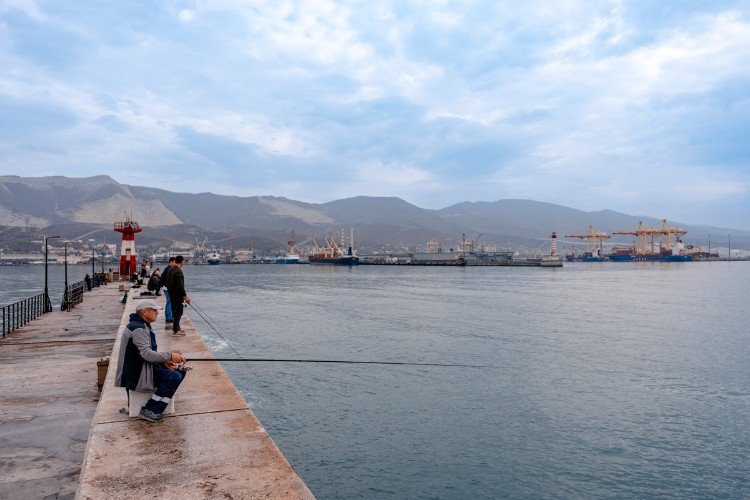 рыбаки сидят на пирсе