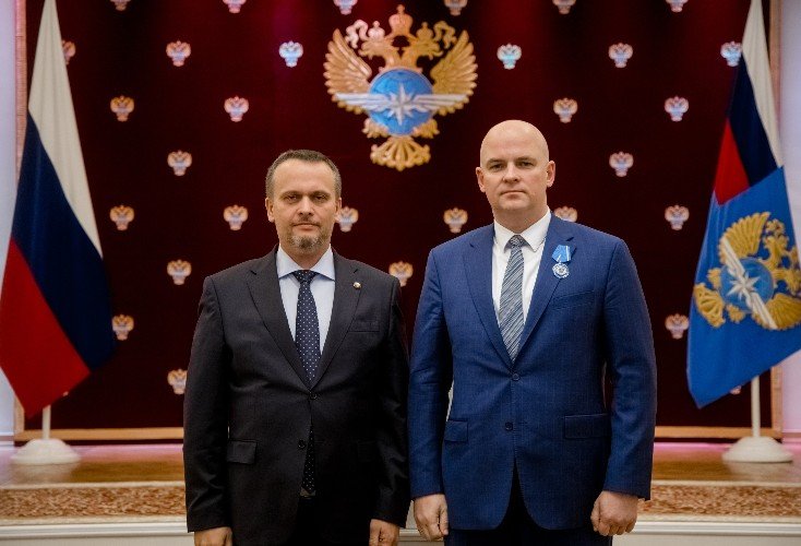 директор аэропорта Сочи стоит на фоне герба