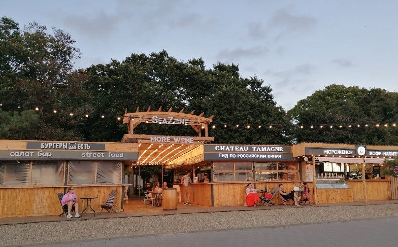 Люди отдыхают у кафе