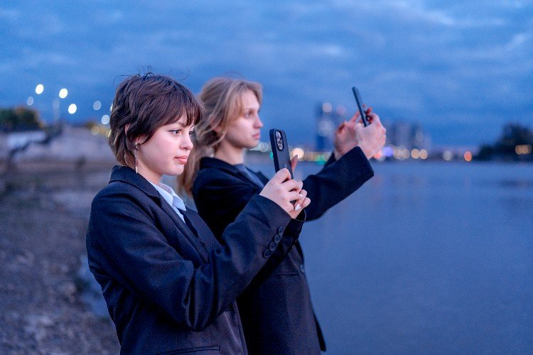 девушки стоят с телефонами