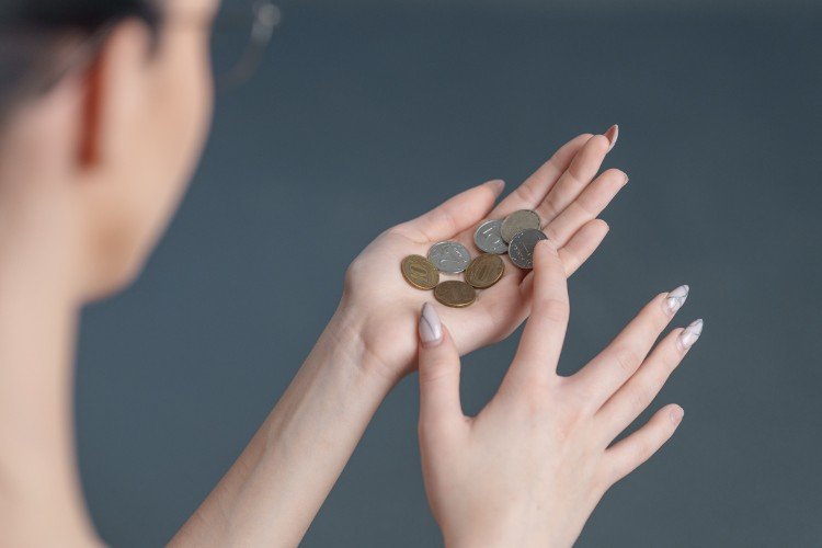 девушка держит в руке мелочь