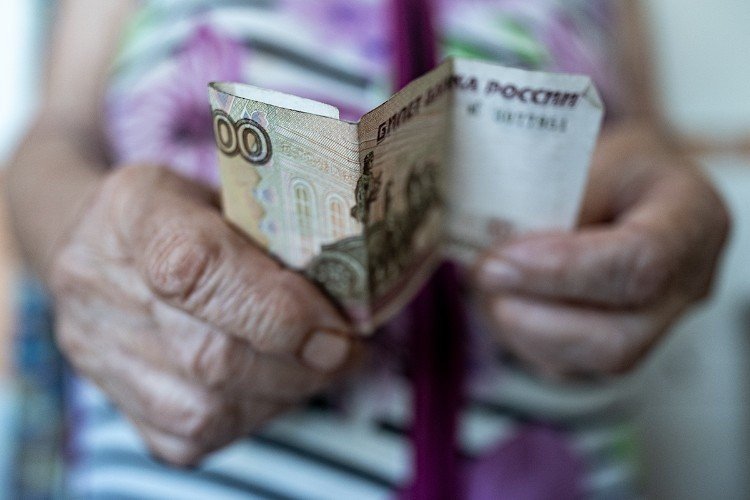 руки держат сторублевую купюру