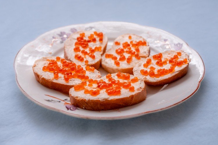 бутерброды с икрой лежат на тарелке