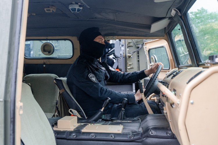 мужчина в балаклаве сидит в машине