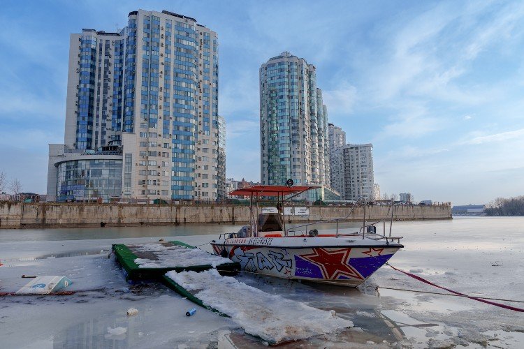 катер стоит в замерзшей реке