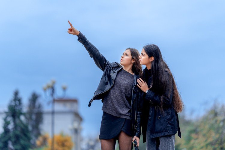 Девушка указывает подруге на БПЛА в небе