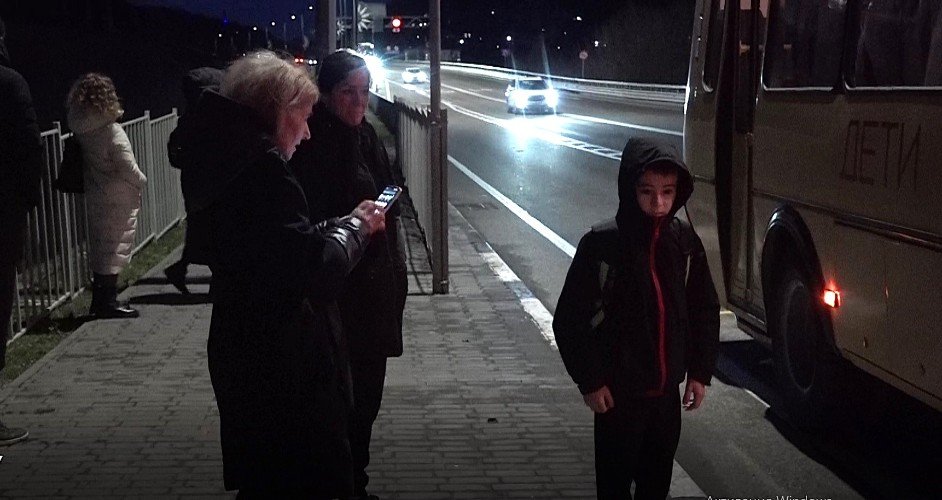 люди стоят на остановке