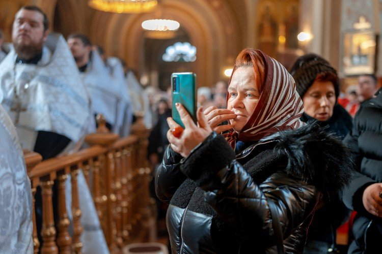 Женщина в православной церкве смотрит YouTube