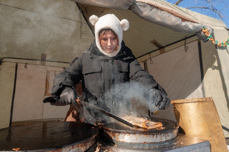 Женщина печет блины