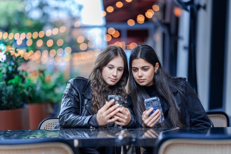 девушки смотрят в телефоны