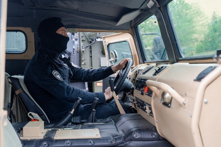 мужчина в балаклаве сидит в машине