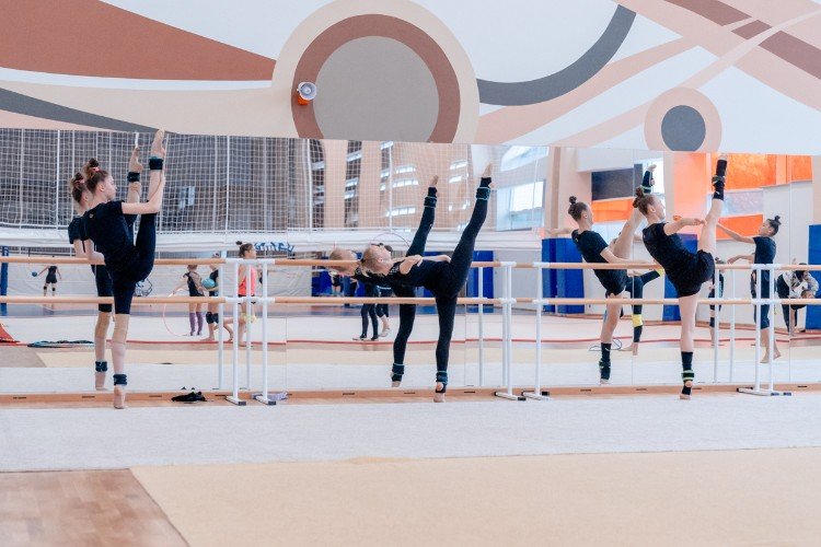 гимнастки разминаются в спортзале