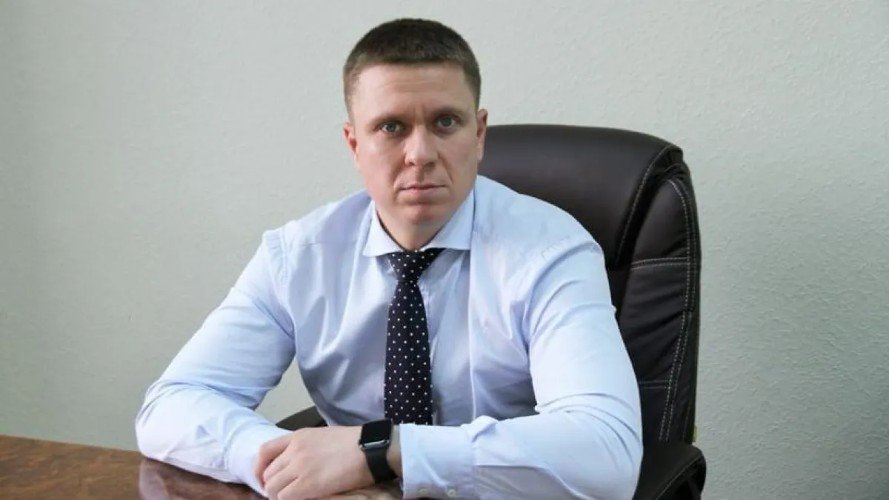 Мысаков сидит за столом