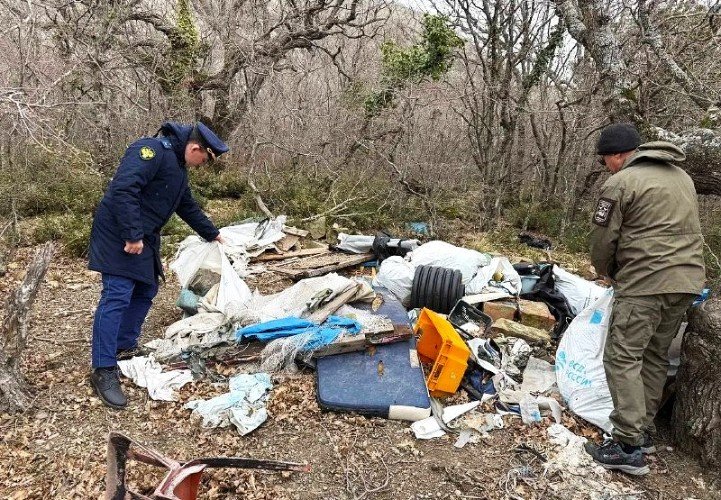 мужчины стоят около свалки мусора