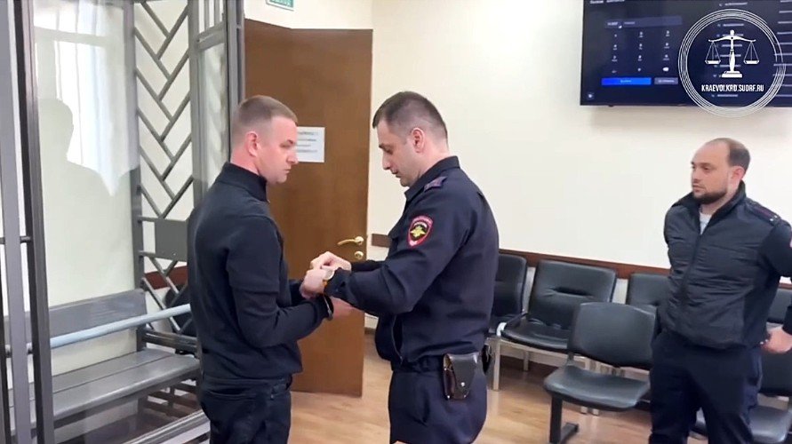 пристав надевает наручники на мужчину