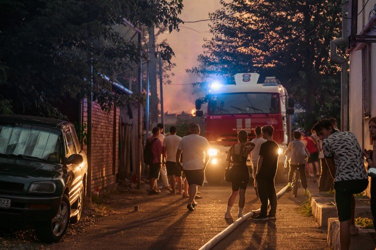 люди стоят около пожарной машины