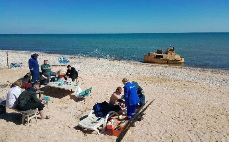 люди сидят на берегу