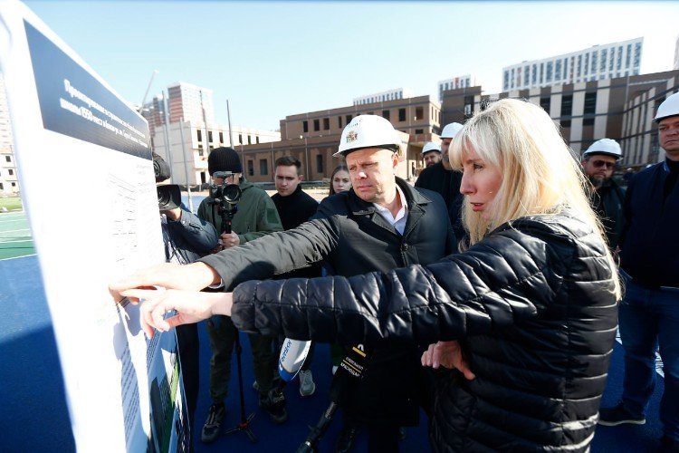 Анна Минькова тычет пальцем в план