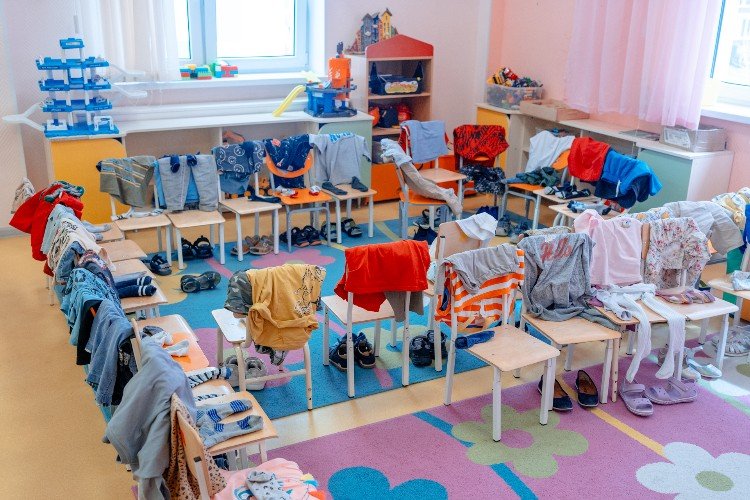 вещи висят на стульчиках в детсаду
