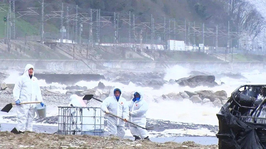 Люди с лопатами стоят на берегу