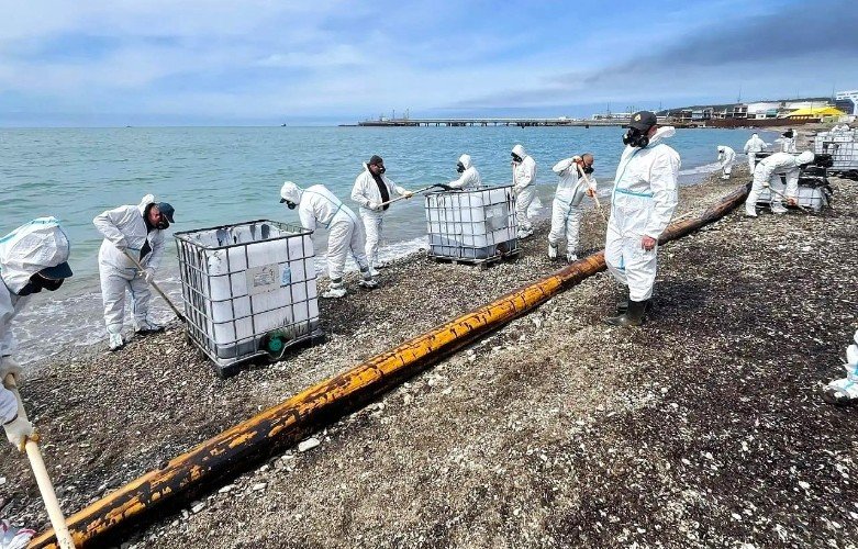 спасатели убирают нефть на берегу