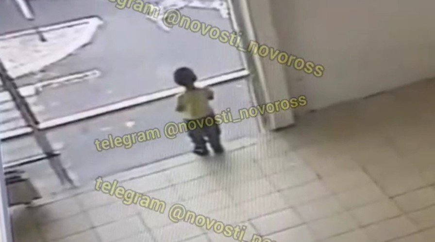 малыш стоит у окна