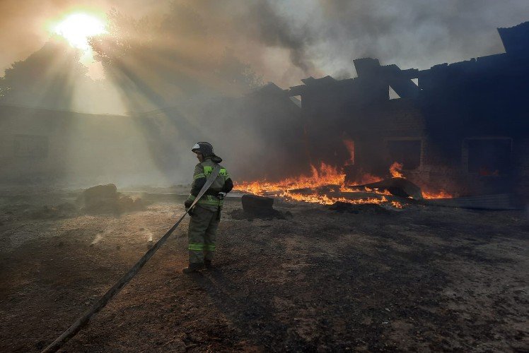 пожарный стот около горящего здания