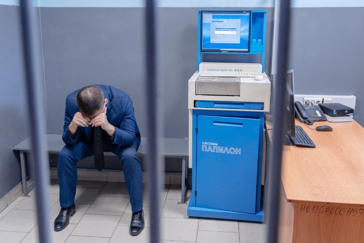 мужчина сидит в полиции