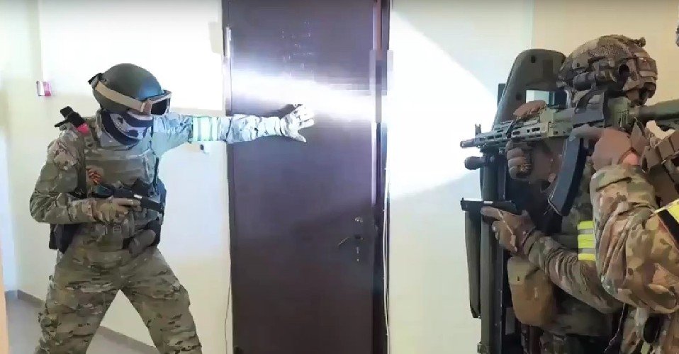 Силовики стоят у двери с оружием