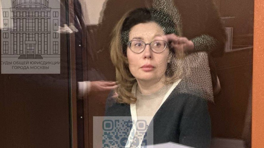Женщина сидит за стеклом