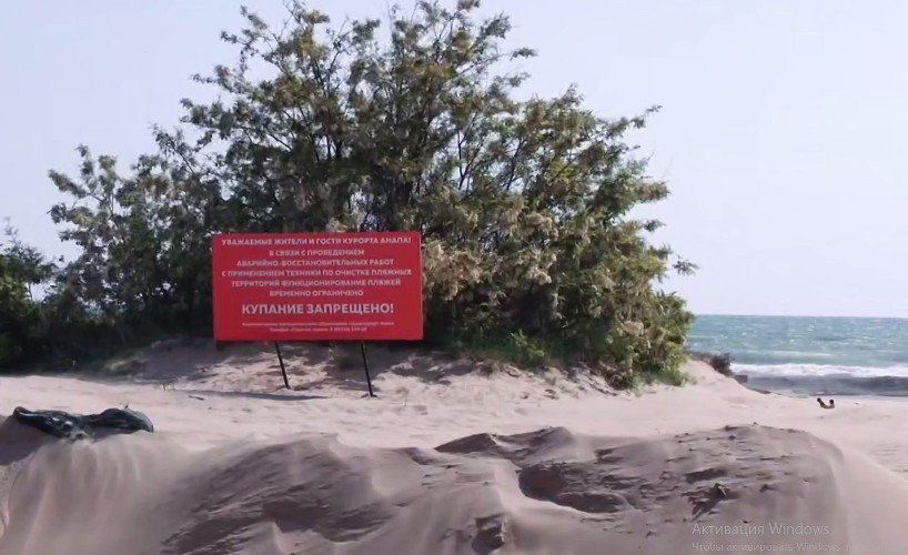 табличка стоит на берегу моря