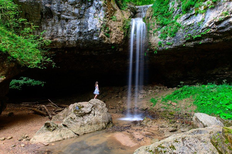 девушка стоит у водопада