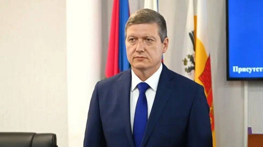 Резуненко стоит на фоне флагов